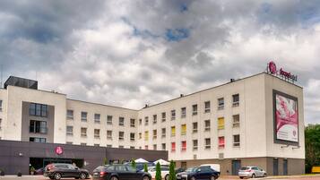 A hotel with a modern facade, multiple windows, and a prominent sign.