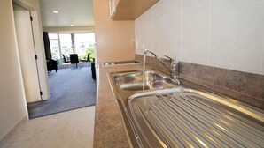 Una cocina moderna con electrodomésticos de acero inoxidable, un lavamanos y una encimera.