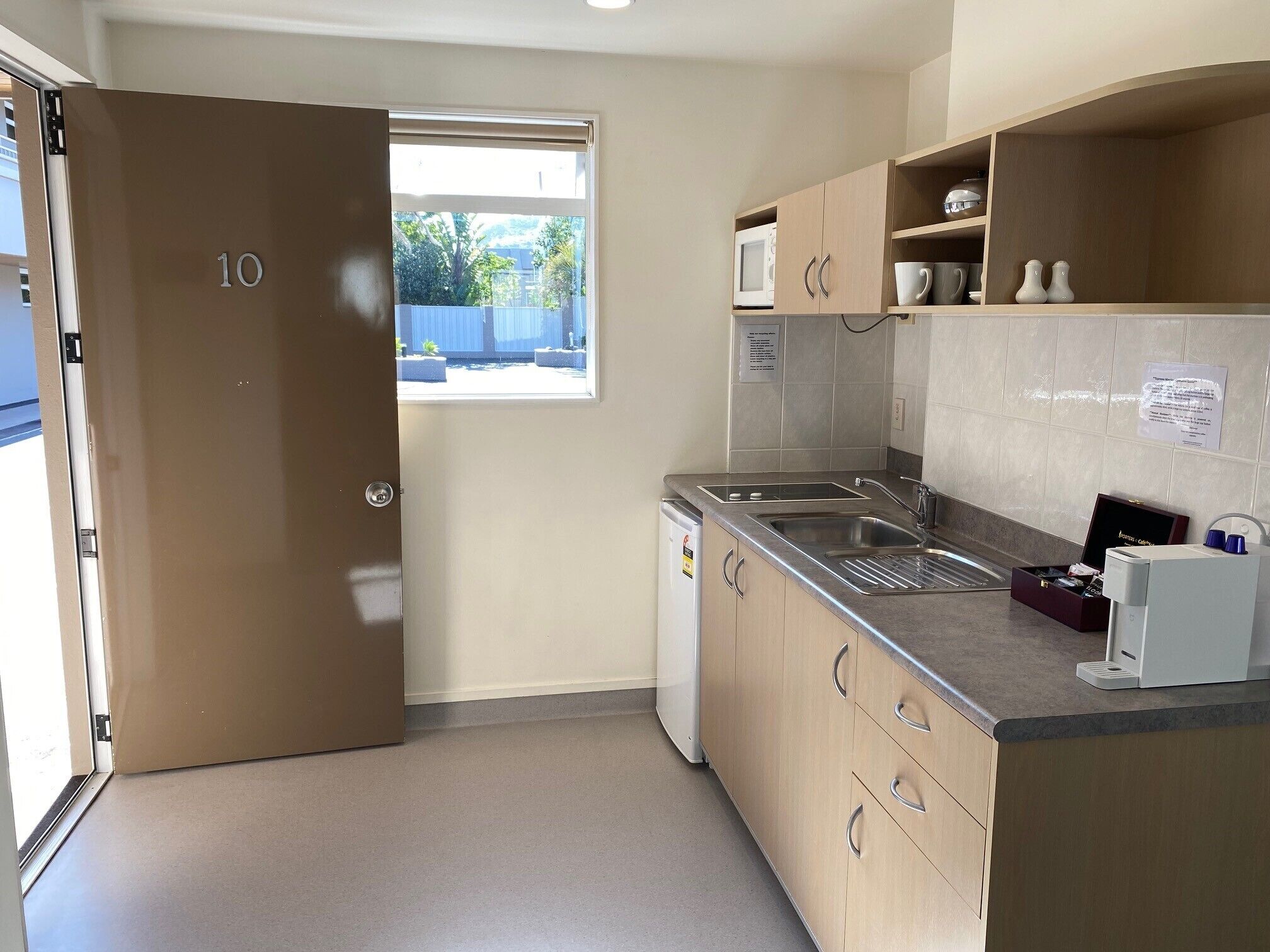 A compact kitchen with a built-in microwave, a sink, and a small countertop.