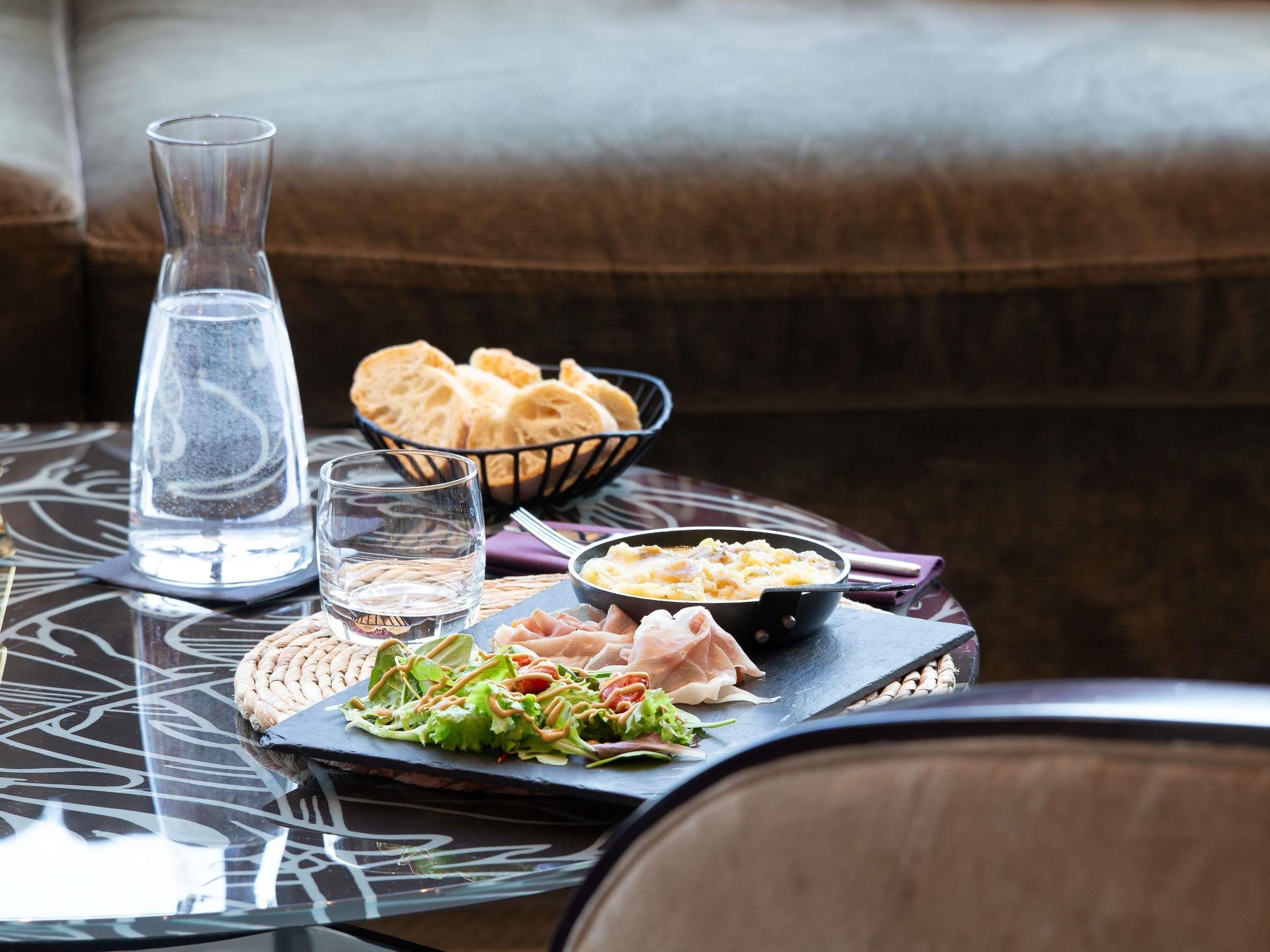 A table with a glass of water, bread, a bowl of soup, and a plate of salad.
