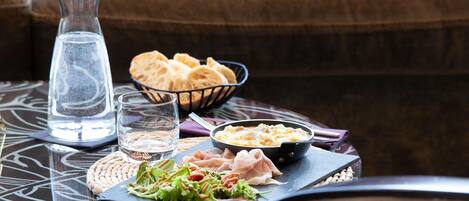 A table with a glass of water, bread, a bowl of soup, and a plate of salad.