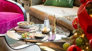 Una mesa de comedor con comida servida, un vaso de agua y una vela.