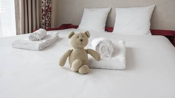 Cozy retreat with a large bed, plush linens, and a teddy bear.