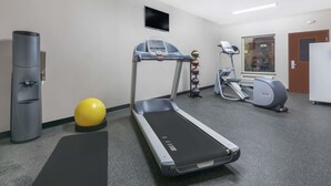 A gym with treadmills, a stationary bike, a water dispenser, and a yellow exercise ball. - Days Inn by Wyndham Dilley (Dilley)