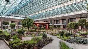 A spacious indoor garden with a glass ceiling, various plants, and a central gazebo. - Radisson Hotel & Convention Center Toluca (Toluca)