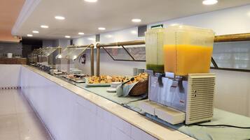 Disposição de buffet com alimentos e dispensadores de suco.