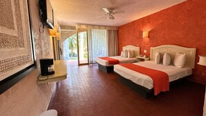 Habitación de hotel con dos camas, ventilador de techo, ventana grande con cortinas y vistas al exterior.