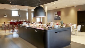 Een moderne keuken met een centraal eiland, eethoek en hanglampen.
