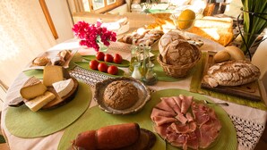 A table with various food items including cheese, bread, and meats. - Hotel Rural Can Feliu (Porreres)