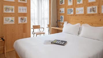 Una habitación de hotel con una cama grande, cabecero de madera e ilustraciones enmarcadas en las paredes.