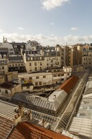 Un área urbana densamente poblada con edificios de varios pisos construidos muy cerca, mostrando una variedad de estilos de techo y detalles arquitectónicos.