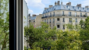 Una hilera de edificios de varios pisos con balcones, rodeados de árboles.