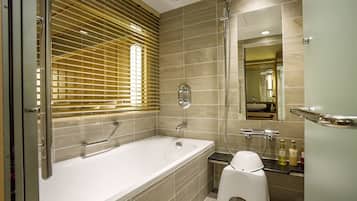 Une salle de bain moderne équipée d’une baignoire, d’une douche et d’un meuble-lavabo avec un miroir.