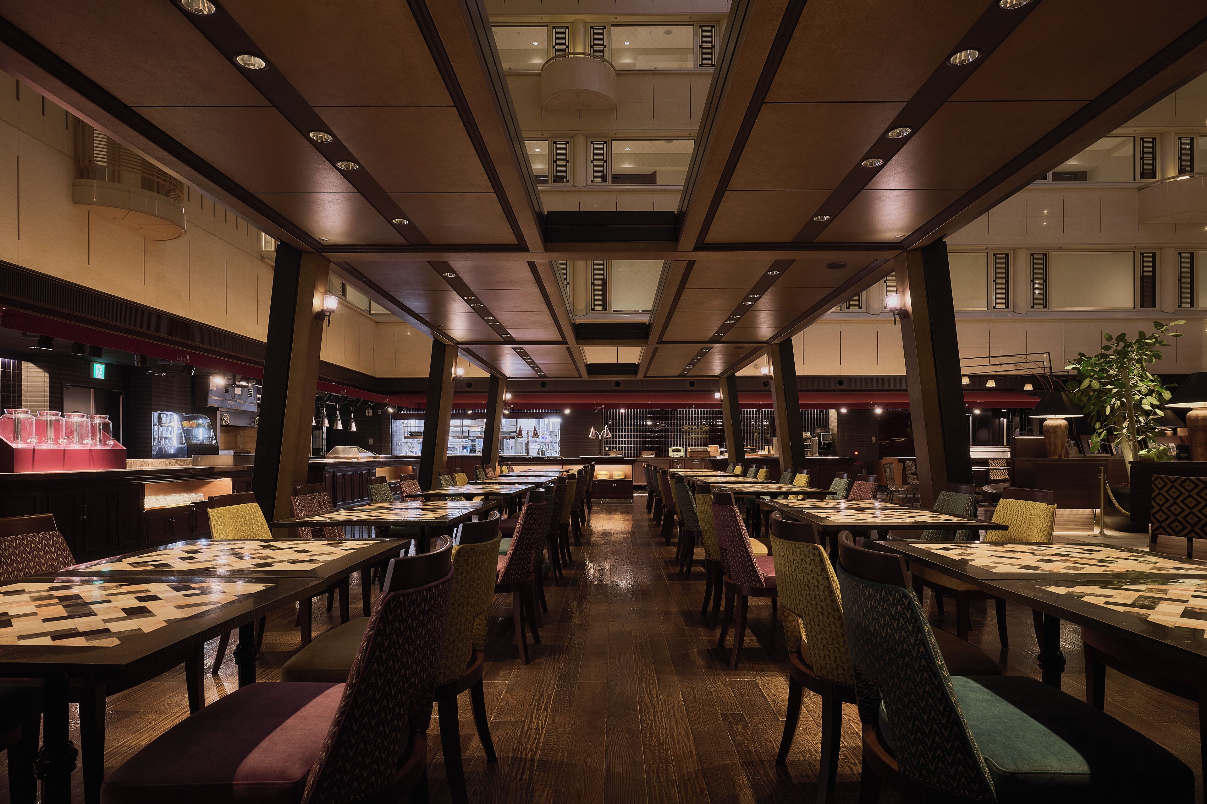A spacious restaurant with high ceilings, multiple dining tables, and a variety of seating options.
