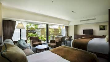 Quarto de hotel com cama, sofá, mesinha, televisão e vista para o exterior.