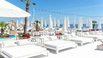 Pantai pribadi di sekitar, pasir putih, dan kursi berjemur