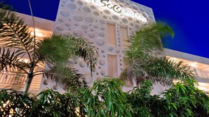 Een hotelgevel met een opvallend cirkelvormig patroon, waarop de naam 'The Sorrento Hotel' duidelijk zichtbaar is.