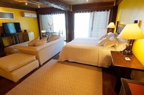 Ein Hotelzimmer mit einem Bett, einer Couch, einem Schreibtisch und einem Fernseher.