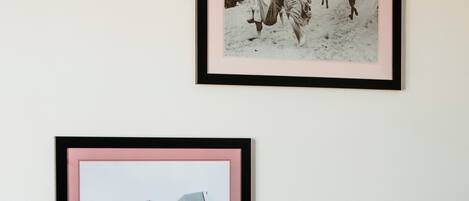 Deux photographies en noir et blanc, encadrées, sont accrochées au mur.