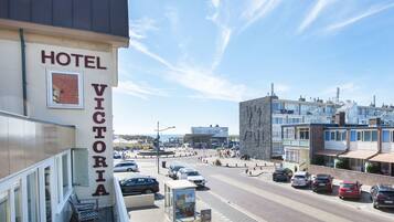 Un hôtel appelé «
Hôtel Victoria
» qui offre une vue sur une rue et d’autres bâtiments.
