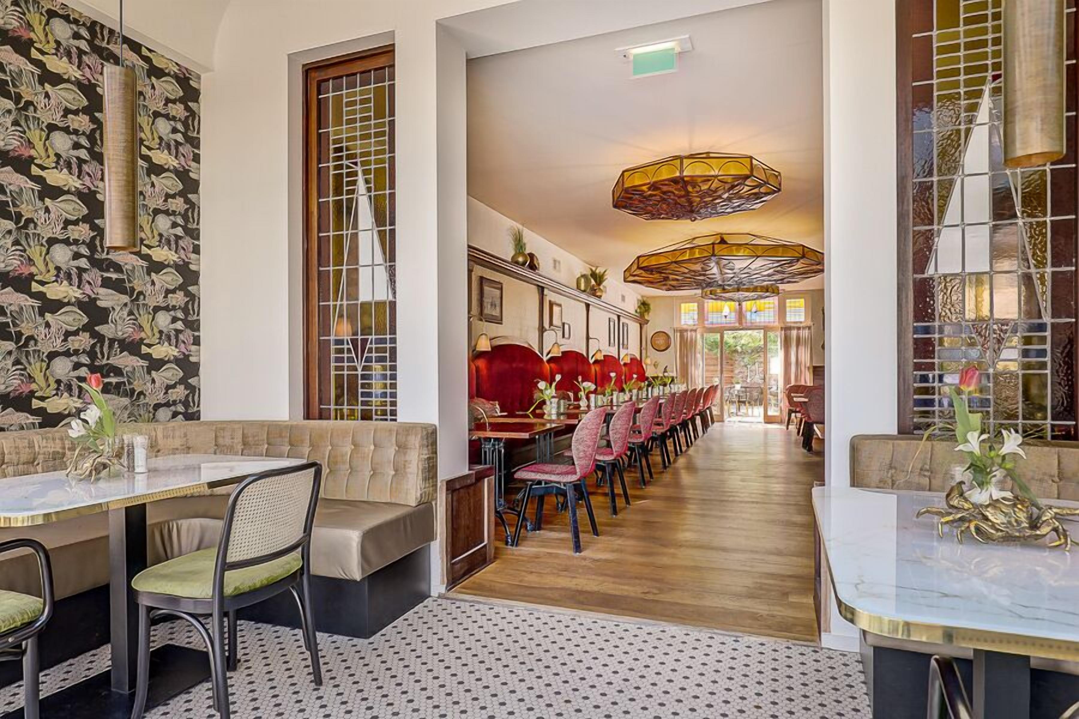 A restaurant with a long dining area, booths, and a patterned floor.