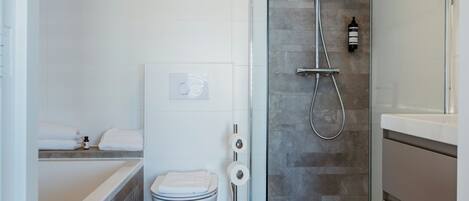 Un baño moderno con bañera, inodoro y ducha.