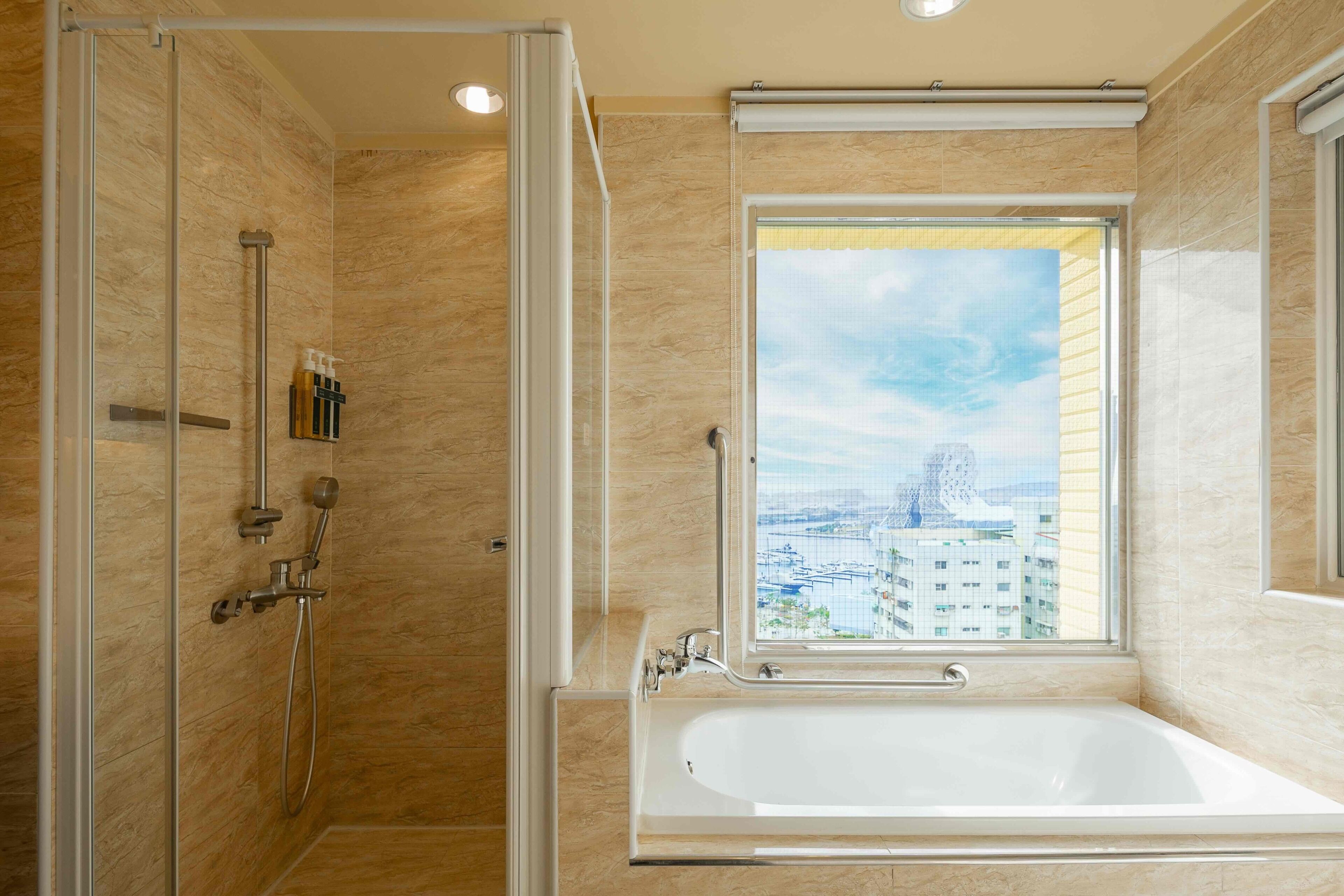 Un baño moderno con ducha a nivel, bañera y ventana con vista panorámica de la ciudad.