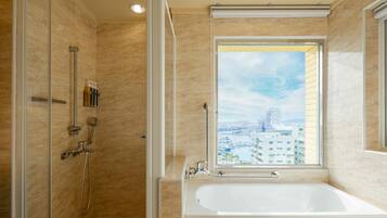 Een moderne badkamer met een ruime douche, een badkuip en een raam met uitzicht op de stad.