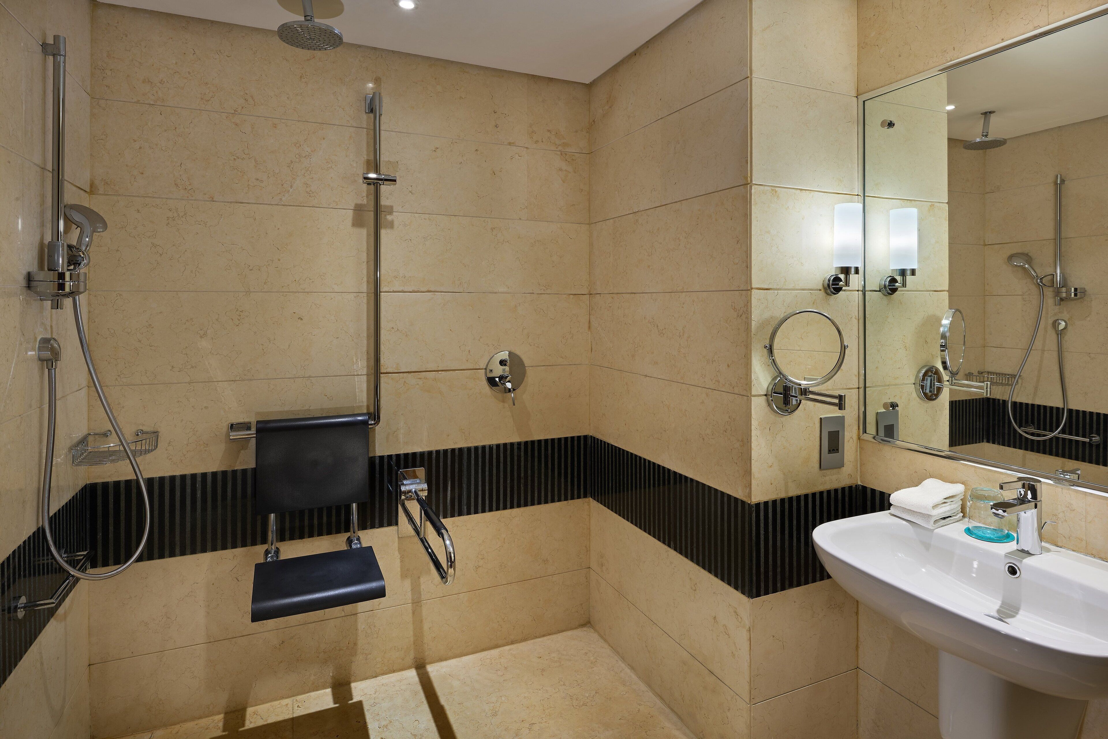 Een moderne badkamer met een douche, wastafel en spiegel.