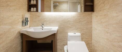 A bathroom with a sink, toilet, and wooden cabinets.