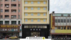 Un immeuble à plusieurs étages portant une enseigne indiquant qu’il s’agit de l’hôtel Kaohsiung City.
