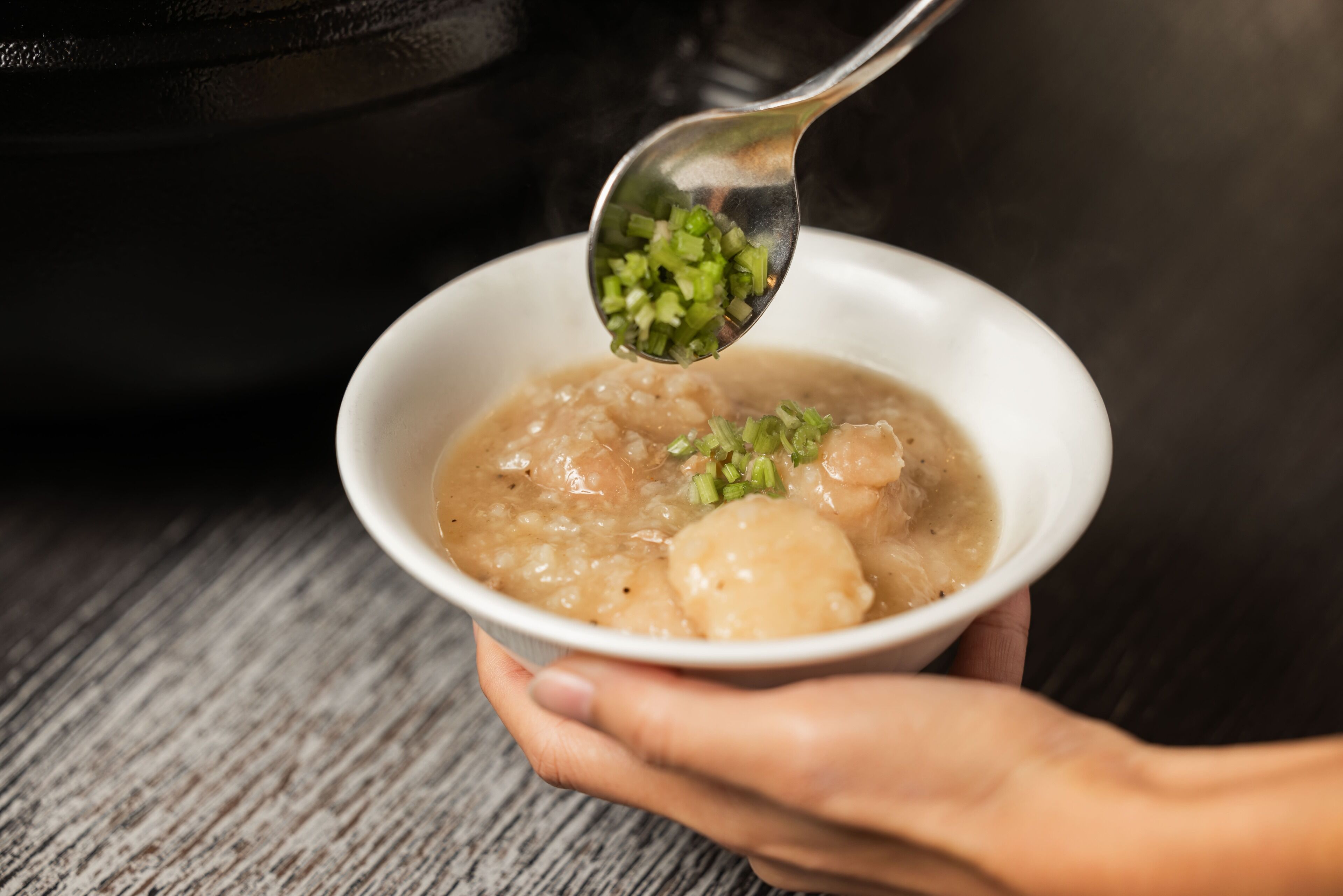 Eine Schüssel Suppe, ein Löffel wird hinzugefügt.