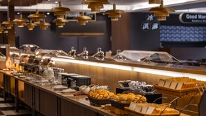 Een buffetopstelling met diverse soorten eten en bestek.