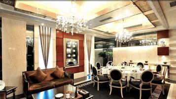 A dining area with a round table set for six, surrounded by upholstered chairs.