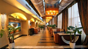 A hotel lobby with a long corridor, seating areas, and large windows. - Rainbird International Hotel (Chengdu)