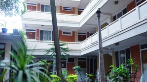 A multi-story building with balconies, potted plants, and a central column. - Hotel Blue Diamond (Kathmandu)