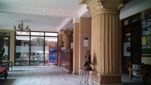 A spacious lobby with a large column, a chandelier, and a statue. - Hotel Blue Diamond (Kathmandu)