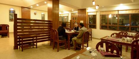 A restaurant with wooden furniture, tables, and chairs.