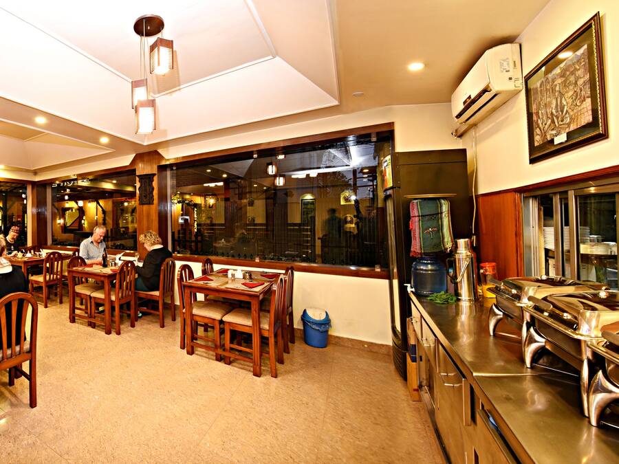 Un restaurante con mobiliario de madera, una zona de bufé y un ventanal grande.