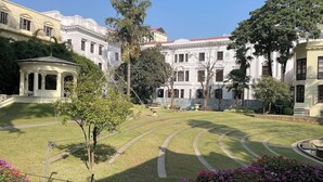 A courtyard with a central lawn, surrounded by classical architecture, including a pavilion and a large building with columns. - Hotel Friend's Home (Kathmandu)