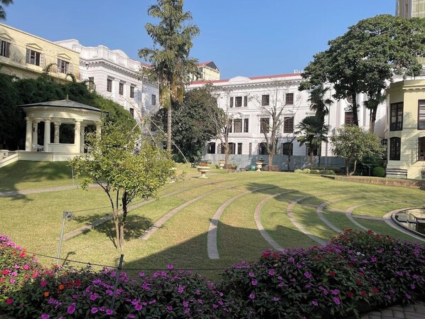A courtyard with a central lawn, surrounded by classical architecture, including a pavilion and a large building with columns. - Hotel Friend's Home (Kathmandu)