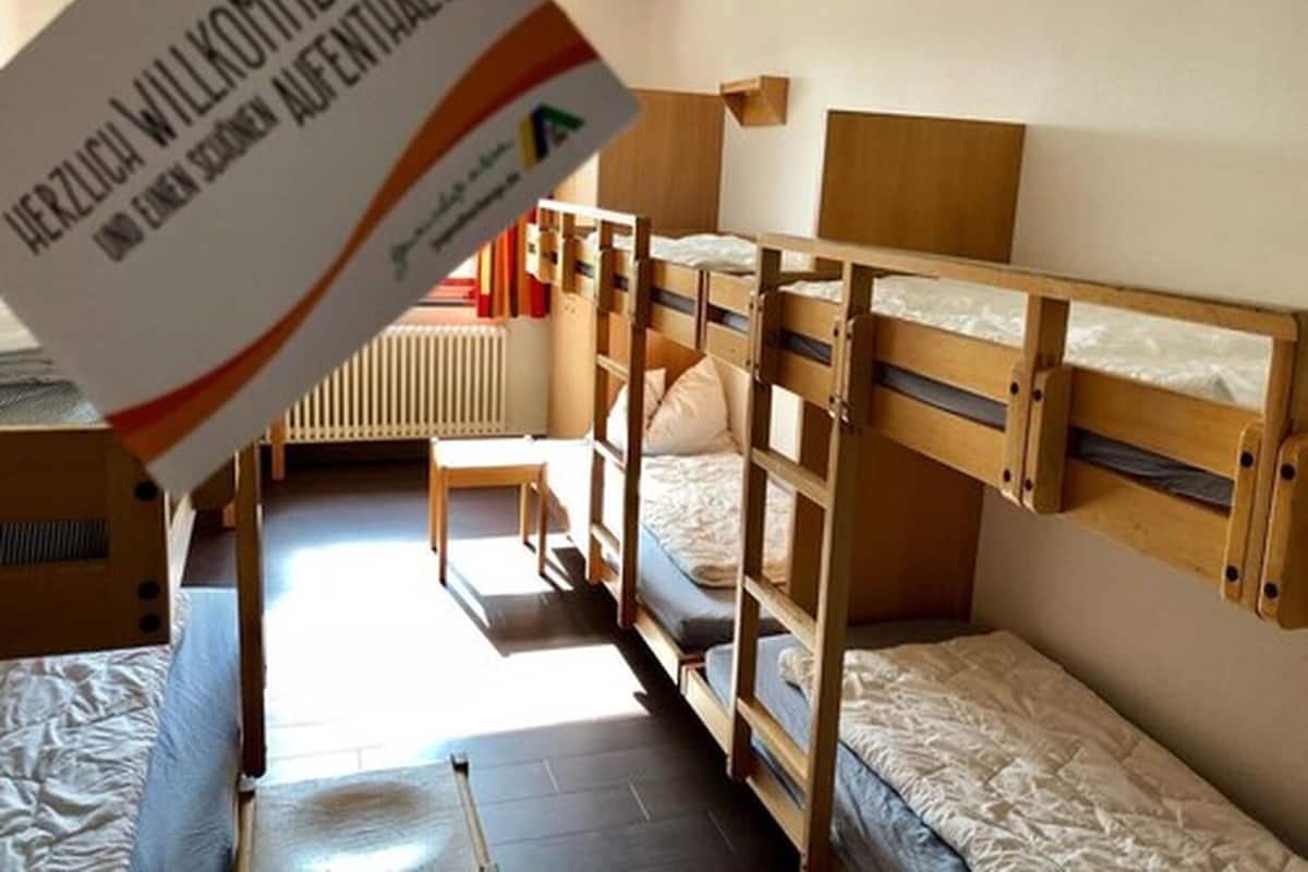 Un dormitorio con literas, un radiador y un escritorio de madera.