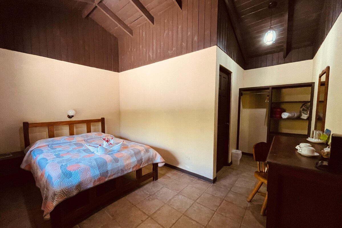 Un dormitorio con cama, escritorio y silla.