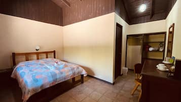 A bedroom with a bed, a desk, and a chair.