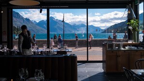 Un restaurante con vistas a montañas y un cuerpo de agua.