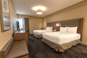 A hotel room with two beds, a desk, and a bench. - Opera House Hotel (Bronx)