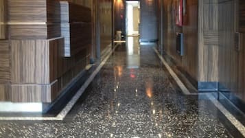 Un pasillo moderno de hotel con piso negro pulido y un emblema decorativo.