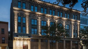 A historic building with a classic architectural style, featuring a prominent entrance and large windows. - Opera House Hotel (Bronx)