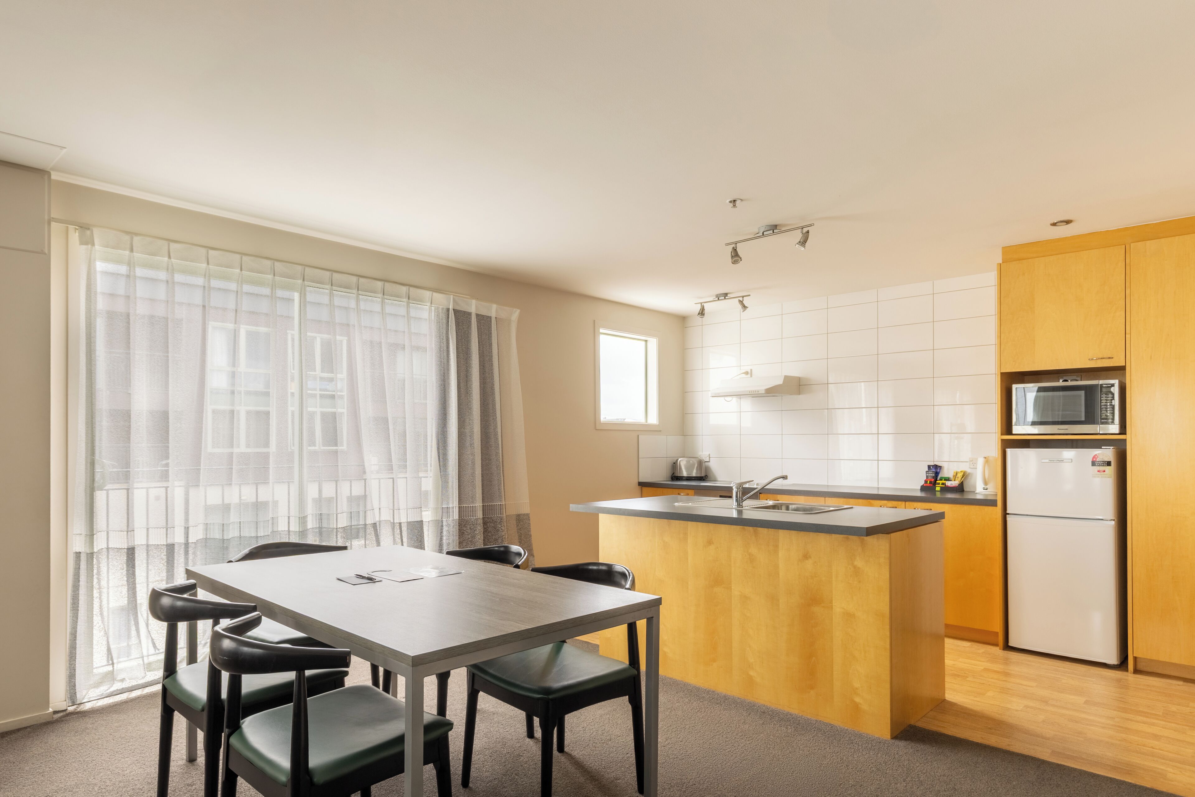 A modern kitchen with a wooden island, a built-in microwave, and a sink.