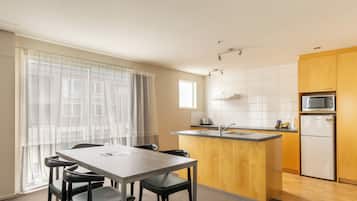 A modern kitchen with a wooden island, a built-in microwave, and a sink.